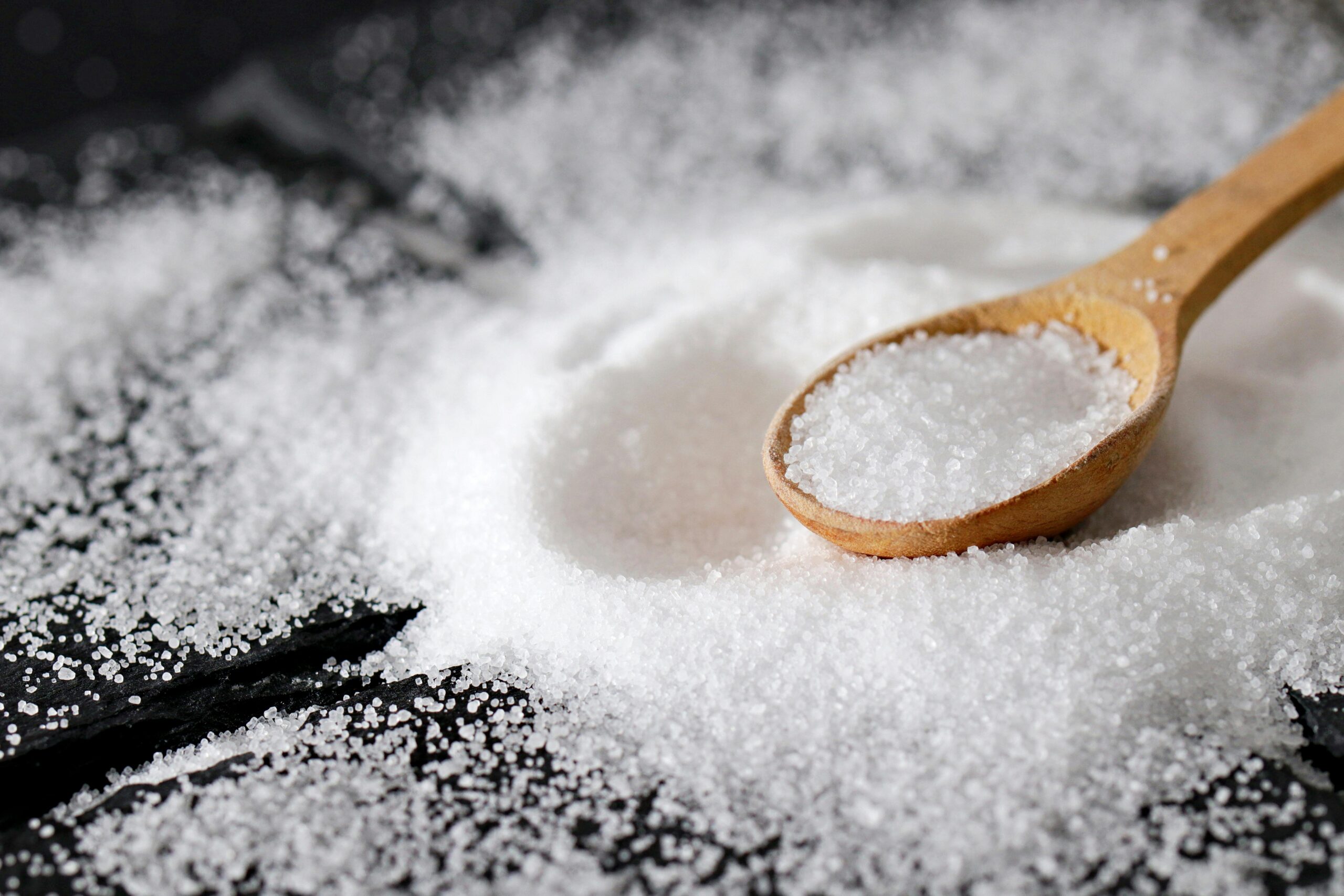 ?Sea Salt vs Table Salt: What’s the Real Difference 1 Wooden spoon filled with white table salt"